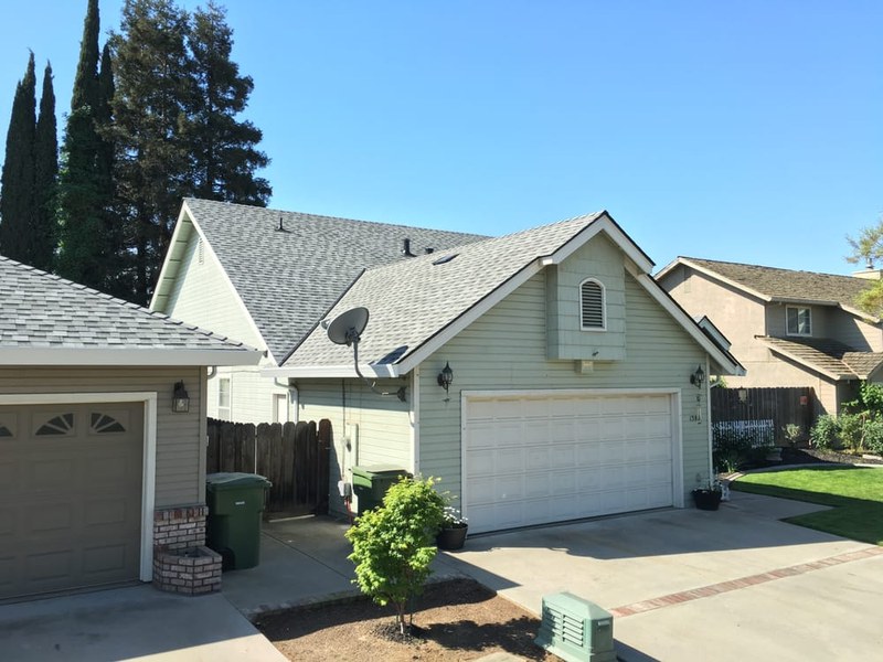 Modern Modesto home with new architectural shingles and decorative garage doors — HOA replacement