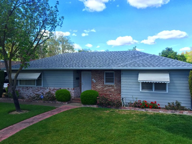 Gray architectural shingles on a brick-front home
