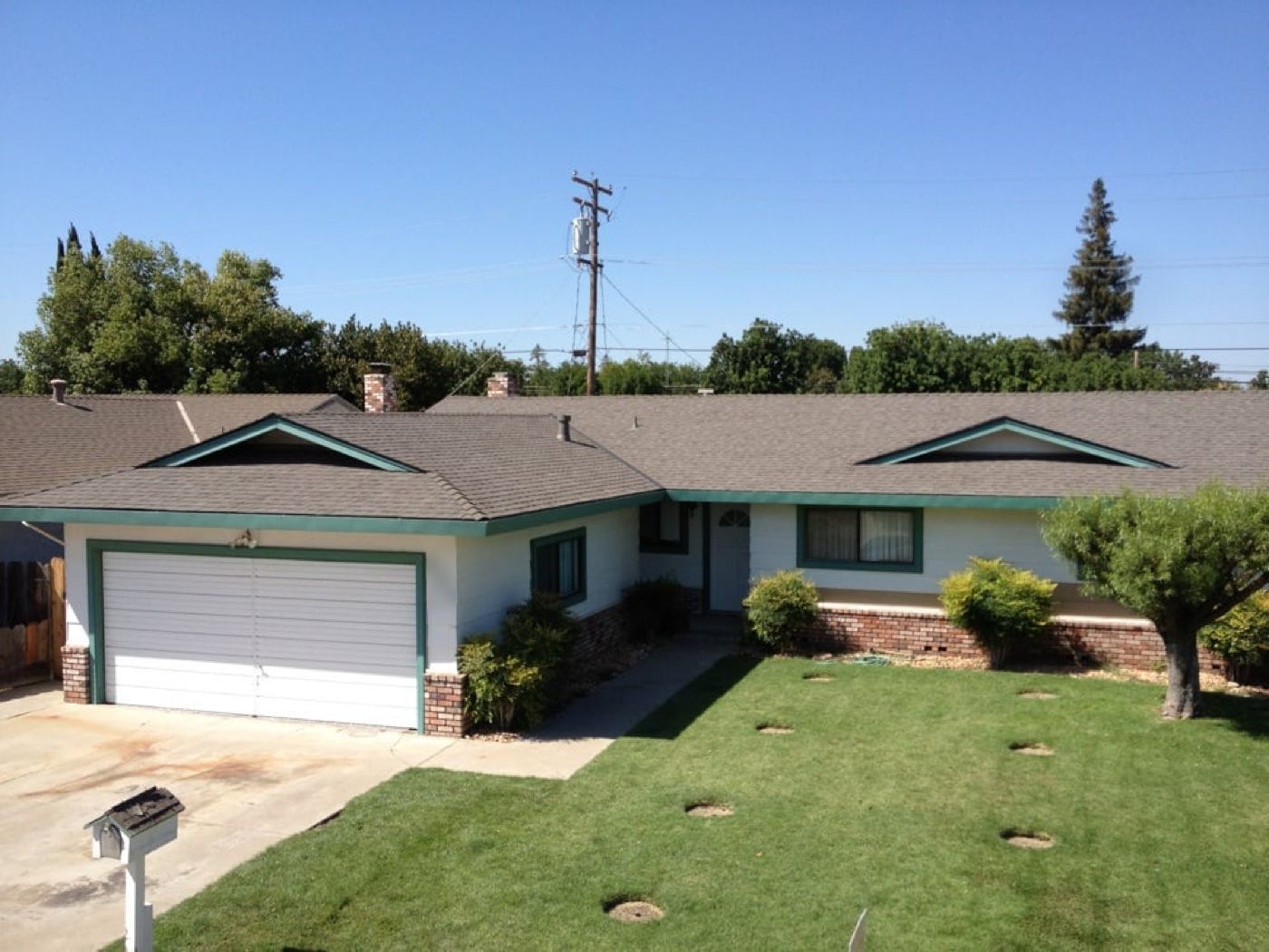 New roof on a single-story ranch home with green trim
