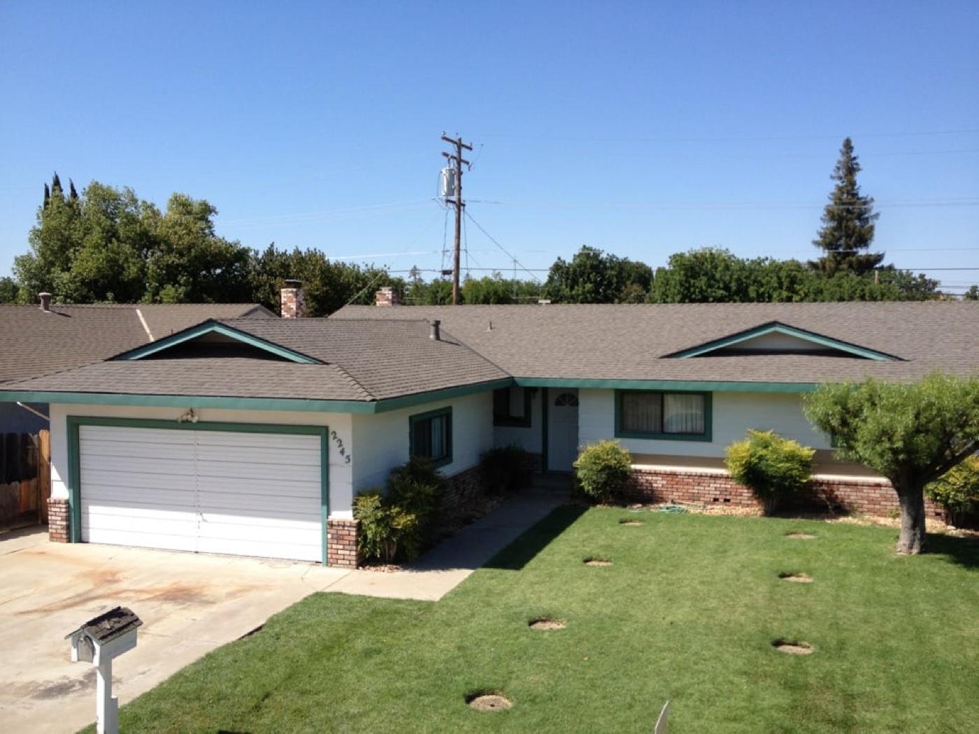 New roof on a single-story ranch home with green trim