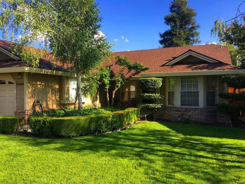 Finished roof on a ranch home shaded by mature trees