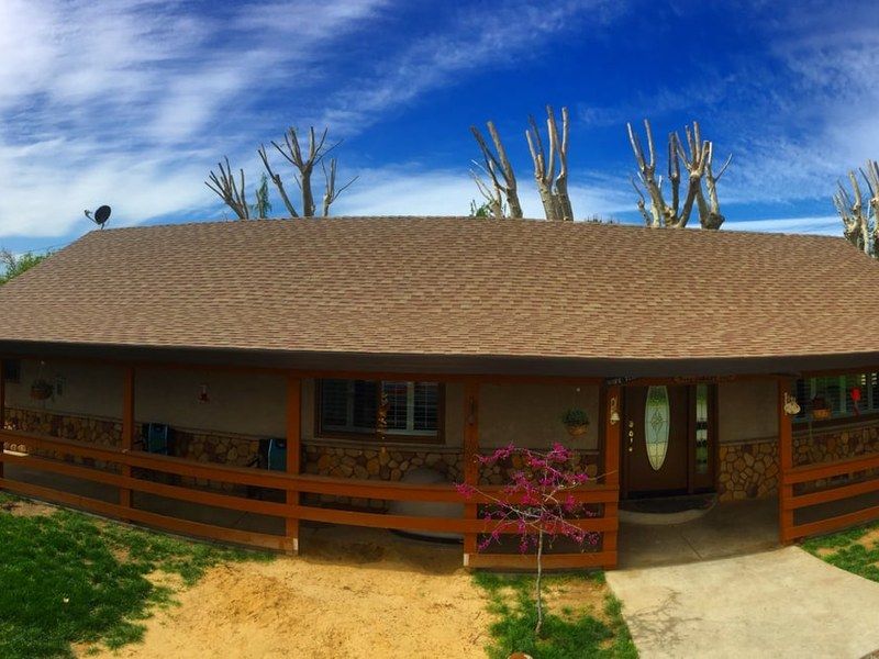 Central Valley ranch home with stone porch posts and new architectural shingles — roof permit guide