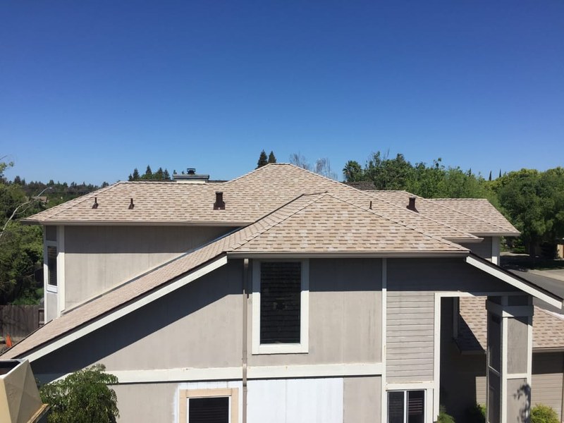 Tan two-story home with newly installed DeHart asphalt shingle roof