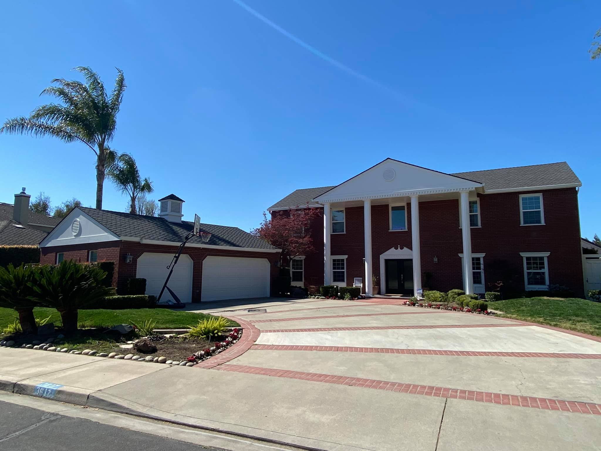 Completed shingle roof replacement on a brick colonial home in Turlock